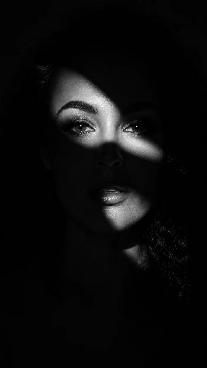Фотосессия чёрно-белый fashion‑портрет с лицом в узких лучах света
